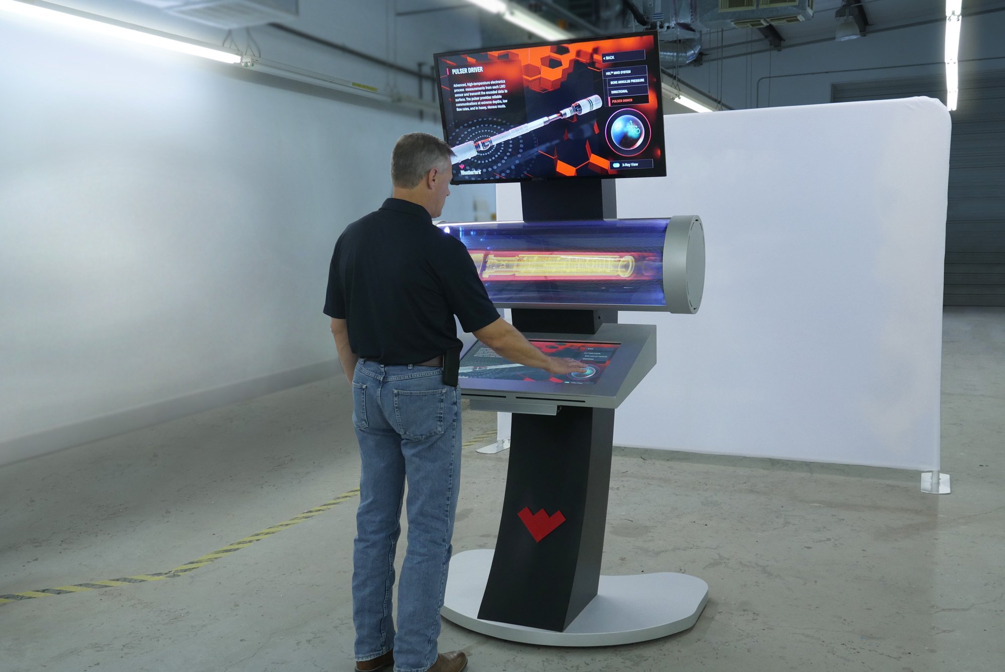 A later Weatherford HoloTube kiosk with the red W mark, a visitor at the console