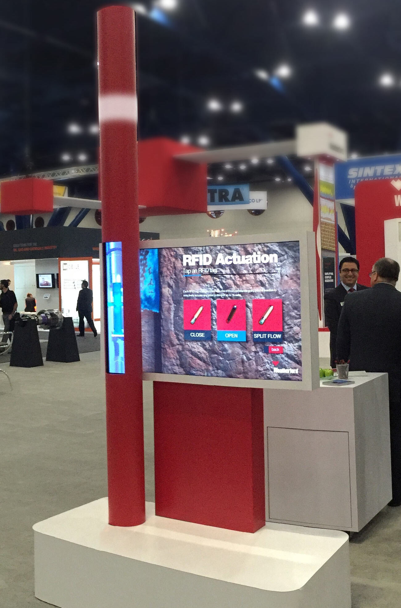 RFID Actuation exhibit: a red pole with an embedded vertical display beside a touchscreen showing Close, Open and Split Flow
